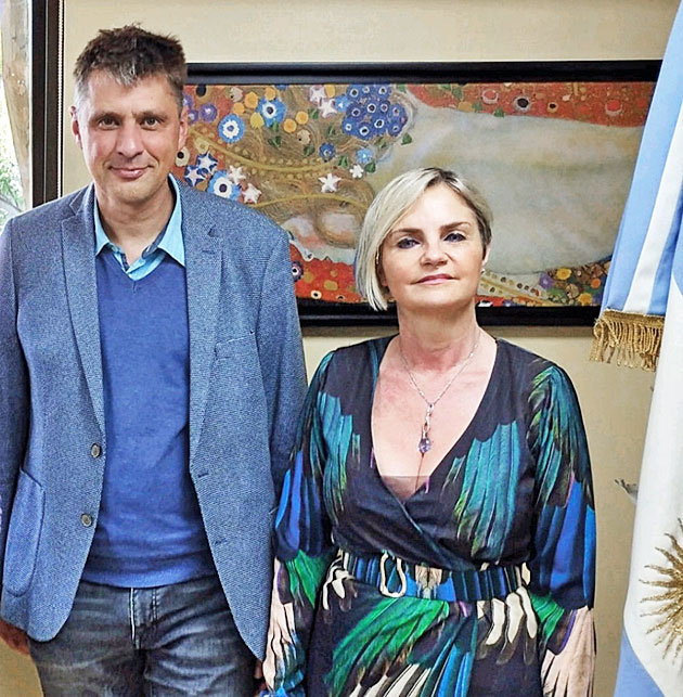 Frau Dr. Perandones und Herr Dr. Rau stehen in einem B�ro neben der Flagge Argentiniens.