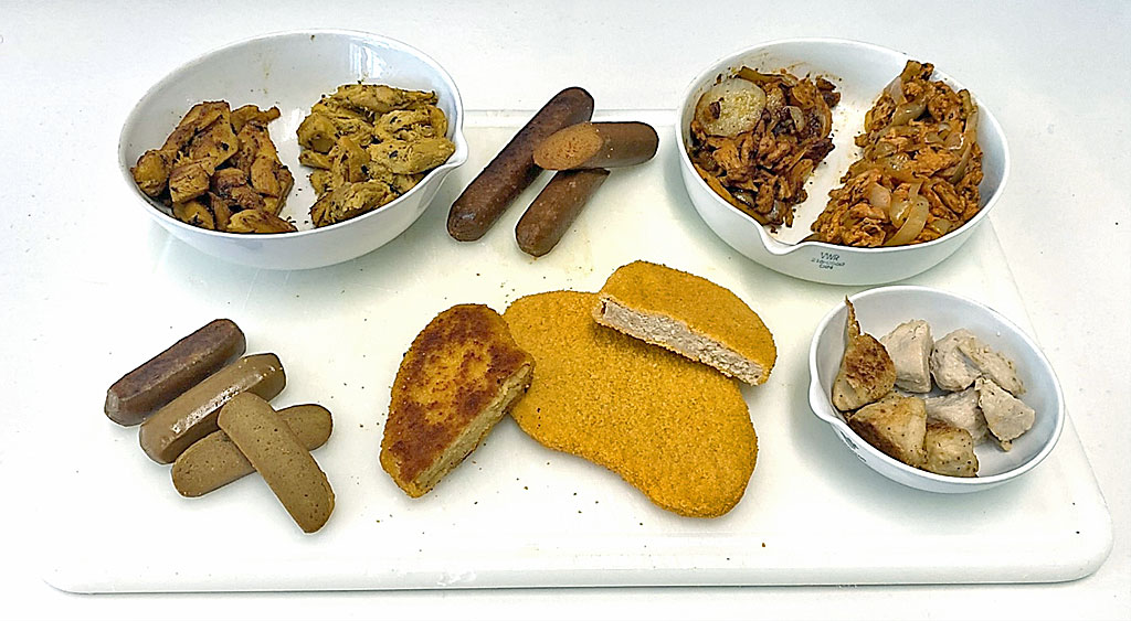 Mehrere teilweise aufgeschnittene Fleischersatzprodukte, angerichtet auf einem wei�en Tablett.